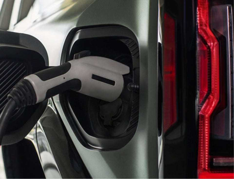 Close up of charging port with charger plugged in on a GMC Hummer EV SUV - Matt LaFontaine GMC in grayling MI